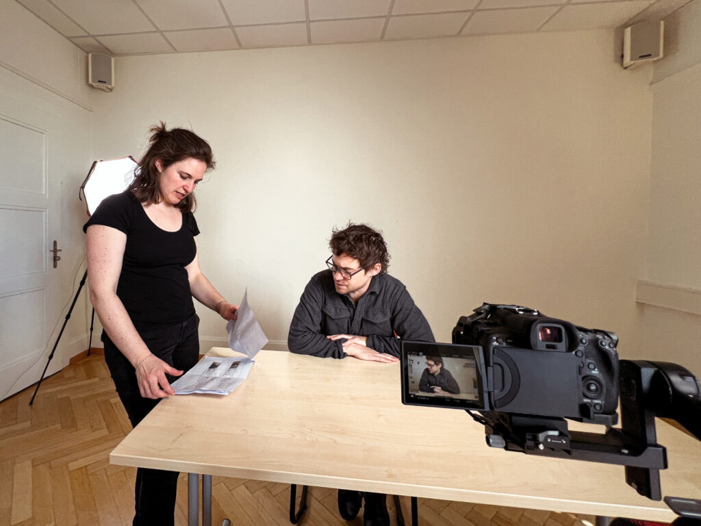 Two people looking at a storyboard for a video.