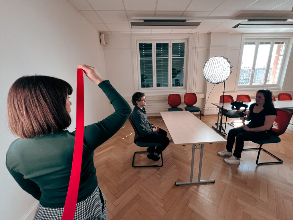 Three people shooting a video in a conference room.