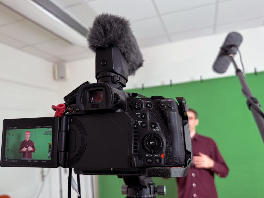 Man standing in front of a greenscreen talking to camera.