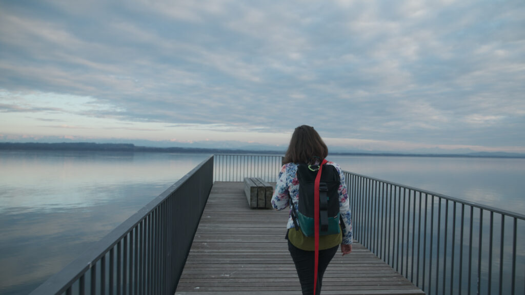 Woman walking on a platform overlooking the lake.